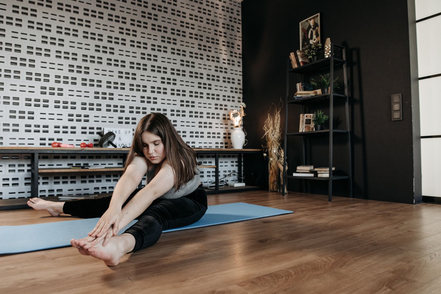 A woman stretching on a mat in a living room