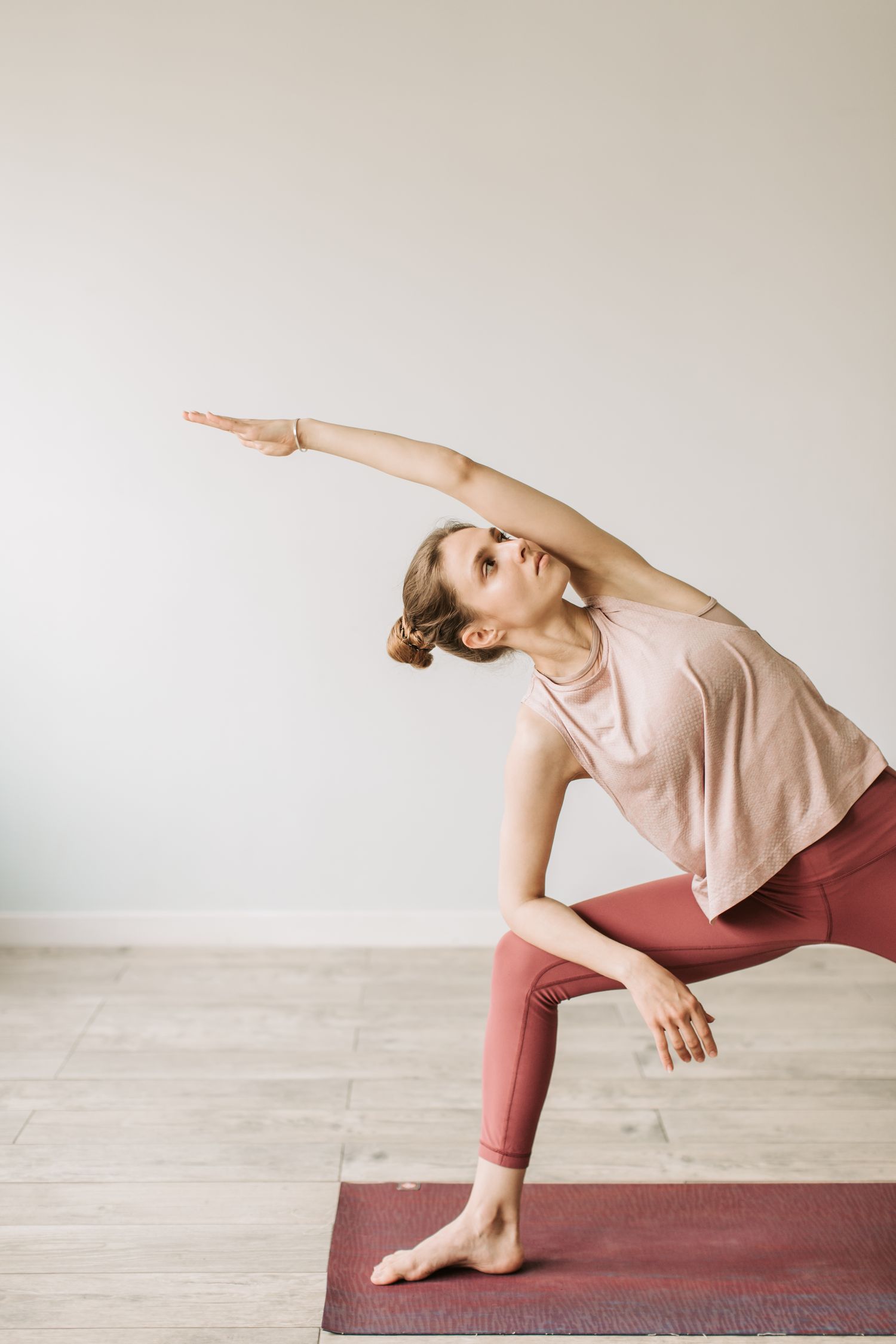 A woman practicing a standing yoga pose indoors